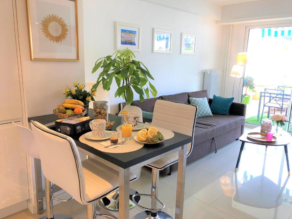 a living room with a table and a couch at Appartement Cosy Calme Central-Terrasse Proche Palais in Cannes