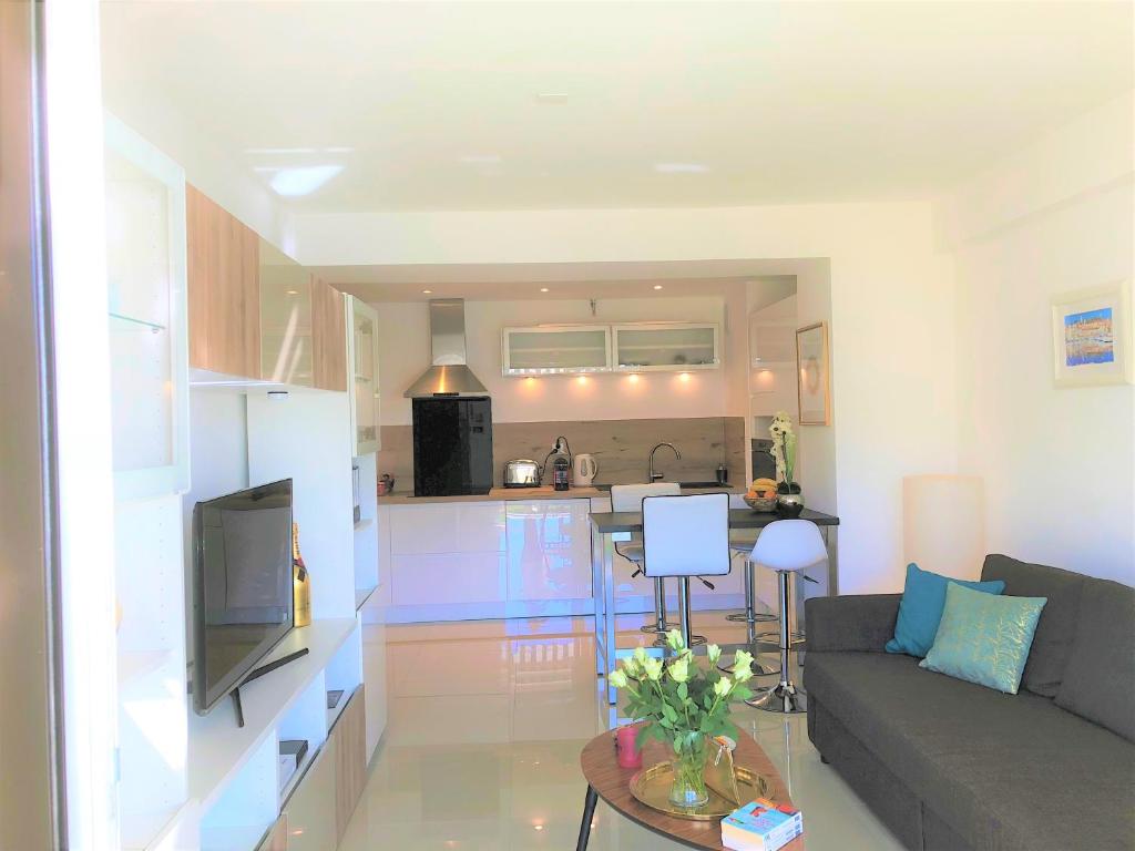 a living room with a couch and a kitchen at Appartement Cosy Calme Central-Terrasse Proche Palais in Cannes