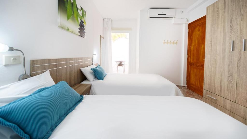 アリナガにあるArmonía Beach 17の白と青の枕が備わる客室内のベッド2台