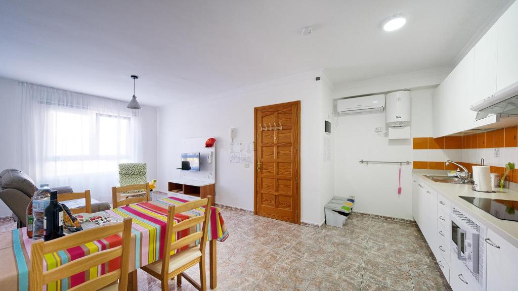 a kitchen with a table and some chairs in a room at Armonía Beach 17 in Arinaga