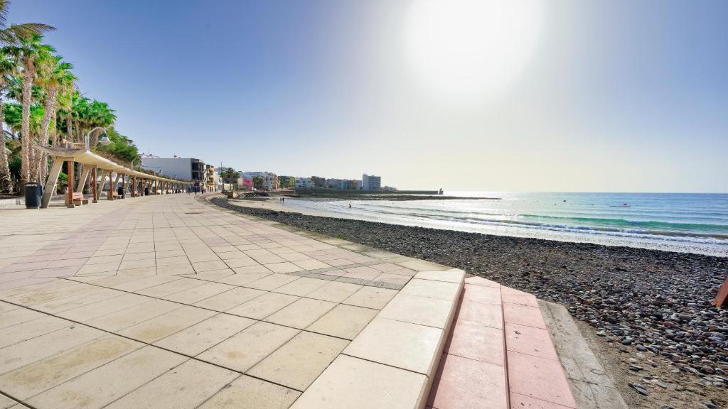 a beach with palm trees and the ocean at Armonía Beach 17 in Arinaga