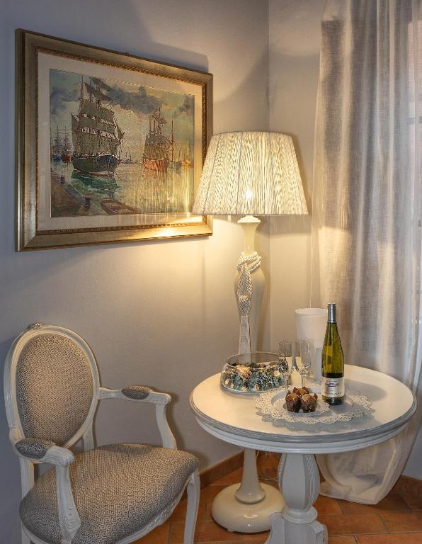 a table with a lamp and a bottle of wine at Rinascimento Bed & Breakfast in Pisa