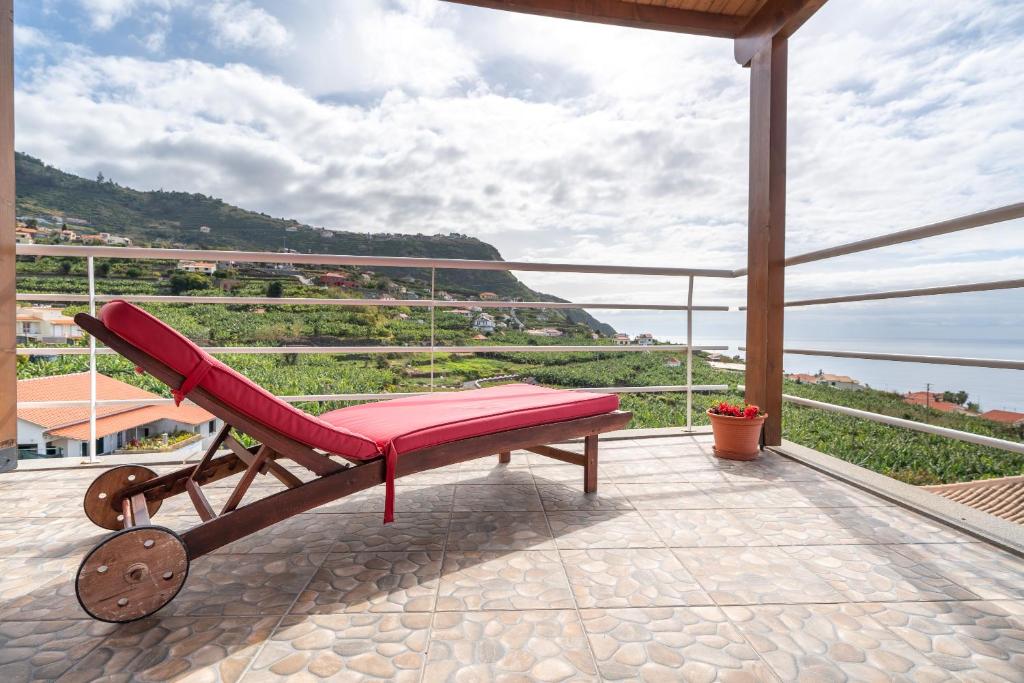 een rode stoel op een balkon met uitzicht bij Apartment Annie 2 in Arco da Calheta