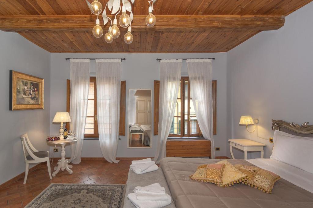 a bedroom with a bed and a table with a chair at Rinascimento Bed & Breakfast in Pisa