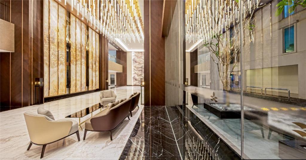 A bright, highly finished lobby lounge beside a glass-lined atrium.