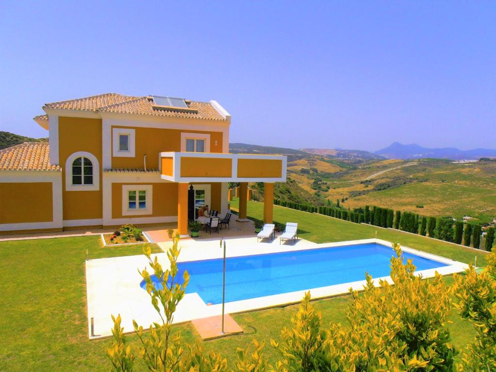 Villa con piscina frente a una casa en Villa PRINCESA KRISTINA, en Castillo de Sabinillas