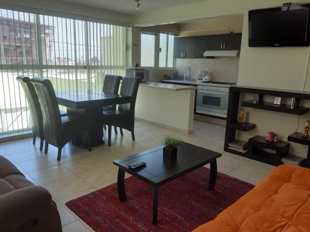 a living room with a table and a kitchen at Departamento cómodo y completo en Toluca in Toluca