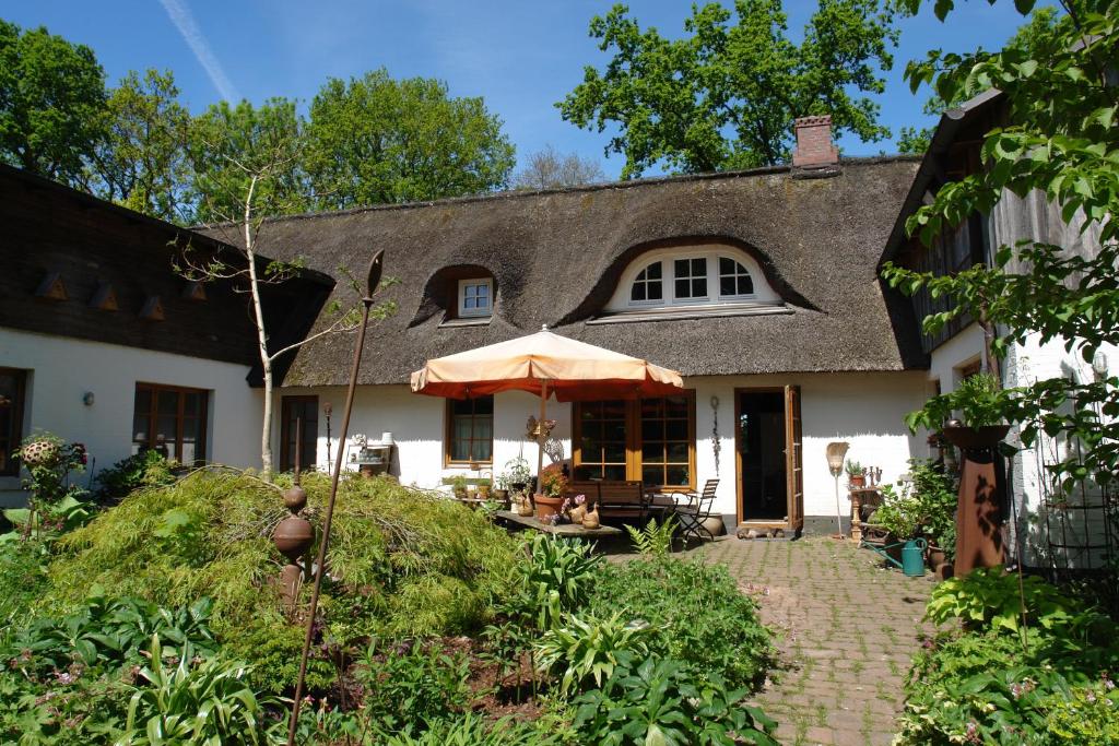 a large white house with a thatched roof at Ferienwohnung im Reetdachhaus Hallerhus in Ahrenviöl