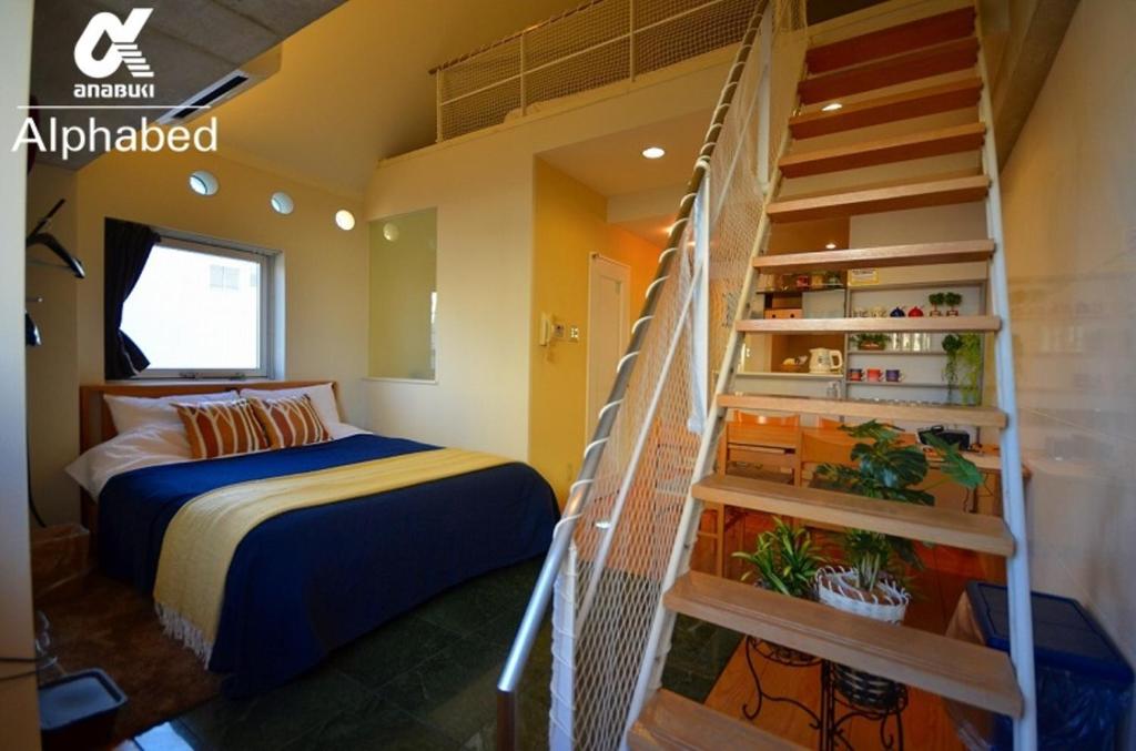 a bedroom with a bed and a spiral staircase at Alphabed TakamatsuKawaramachi 501 / Vacation STAY 21604 in Takamatsu