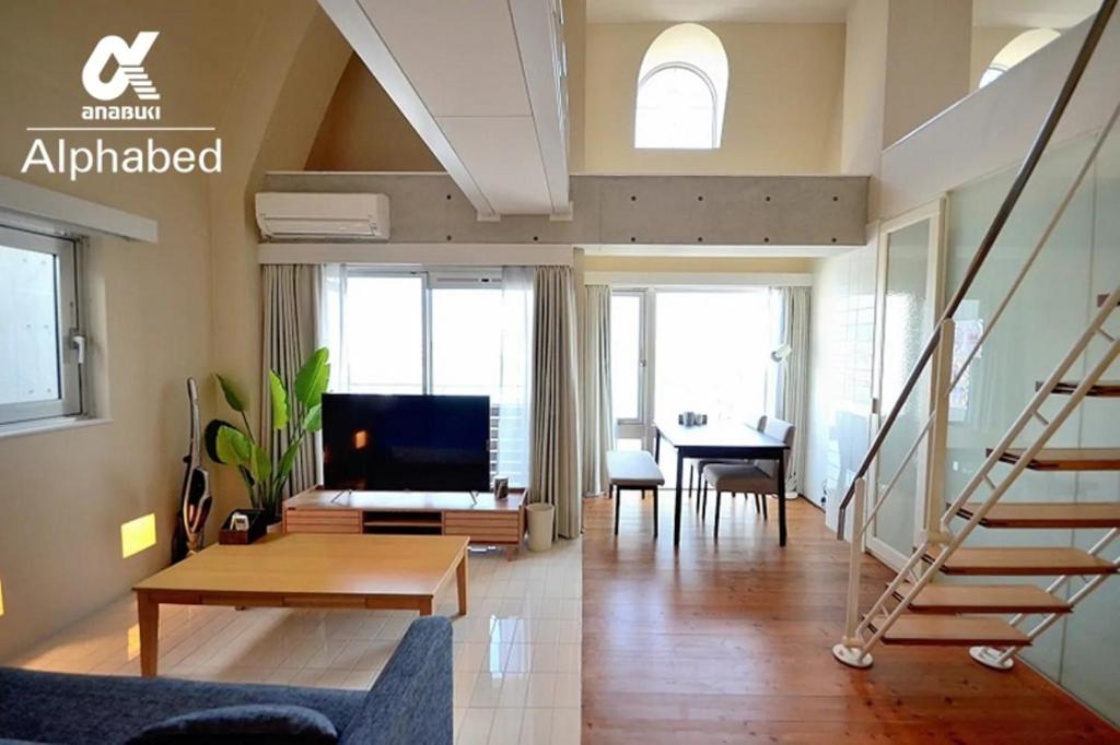 uma sala de estar com uma escada e uma televisão em Alphabed TakamatsuKawaramachi WEST 701 / Vacation STAY 21586 em Takamatsu