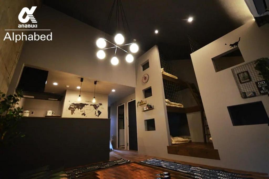 uma sala de estar com uma ventoinha de tecto e uma mesa em Alphabed SunportTakamatsu 702 / Vacation STAY 21868 em Takamatsu