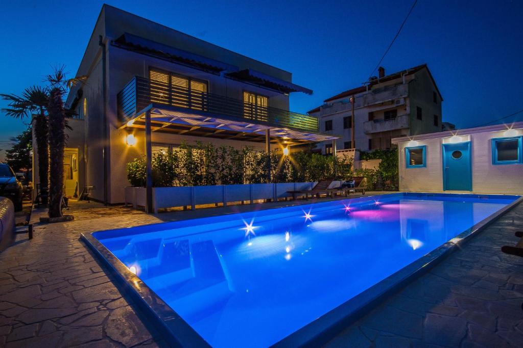 - une piscine en face d'une maison la nuit dans l'établissement Apartments Gardelin Superior 2, à Zadar