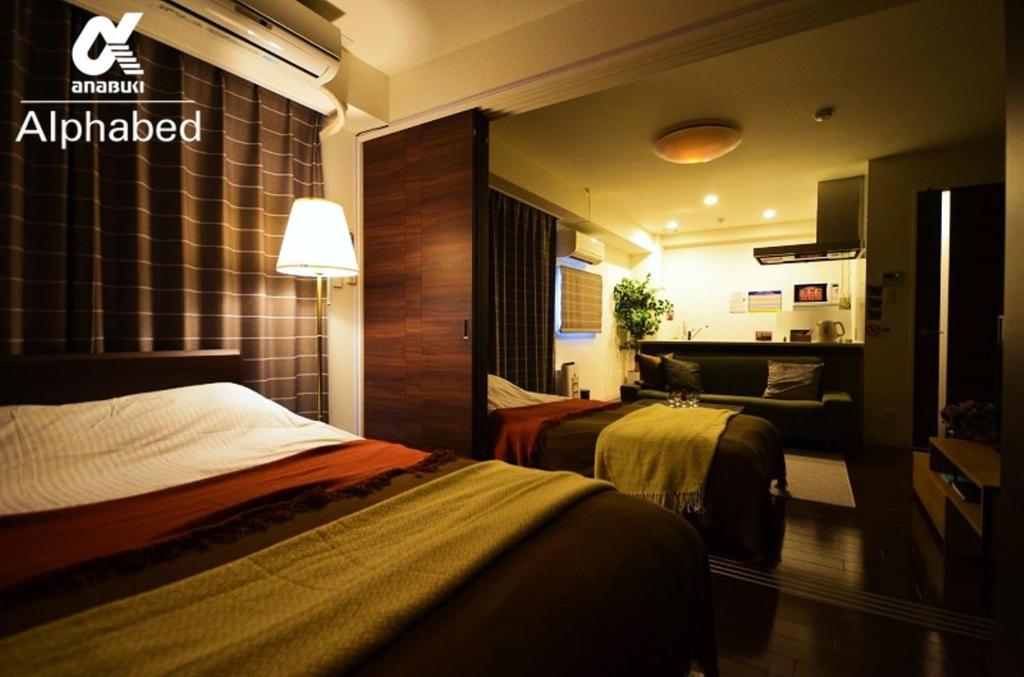 a hotel room with two beds and a couch at Alphabed TakamatsuFurujinmachi 902 / Vacation STAY 21916 in Takamatsu