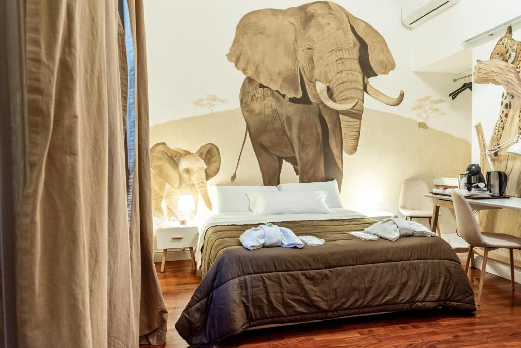 una camera da letto con un letto e un murale a tema elefante di Giro nel mondo a Catania