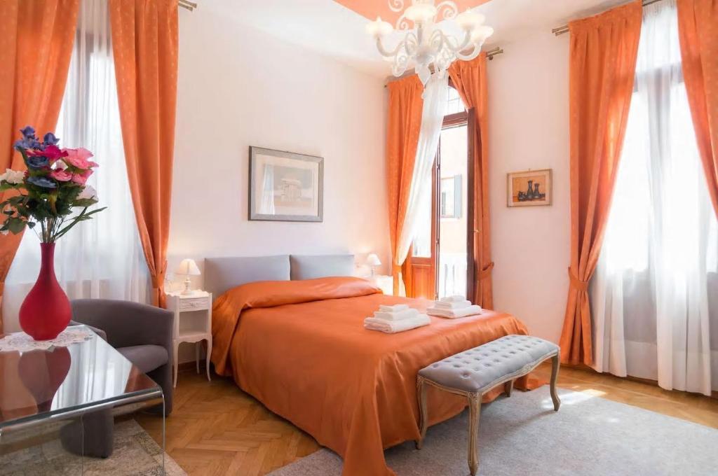 1 dormitorio con 1 cama y un jarrón de flores en Residenza Procuratie Due, en Venecia