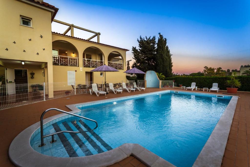 uma grande piscina em frente a um edifício em Villa Welwitshia em Carvoeiro