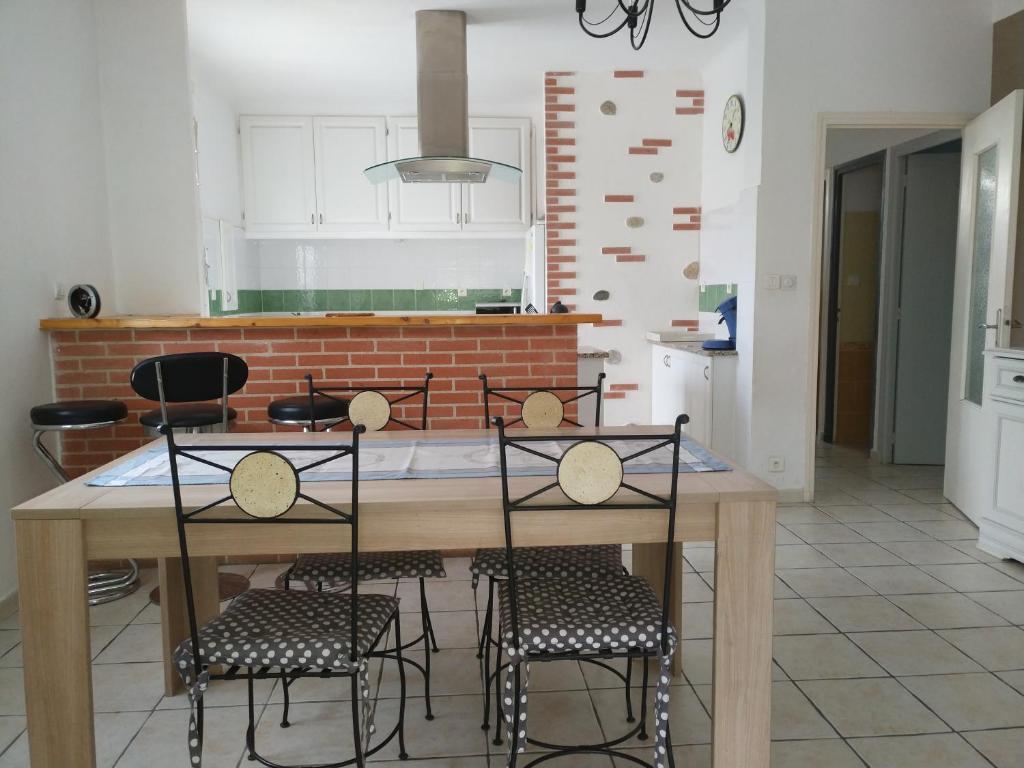 cocina con mesa de madera y sillas en Jolie Villa 6 couchages secteur Calme / proche Montagnes - Plages - ESPAGNE, en Ortaffa