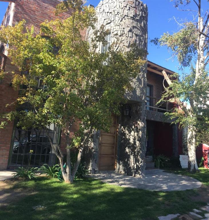 a brick house with a tree in front of it at Apart Hotel Abedules in Puerto Madryn
