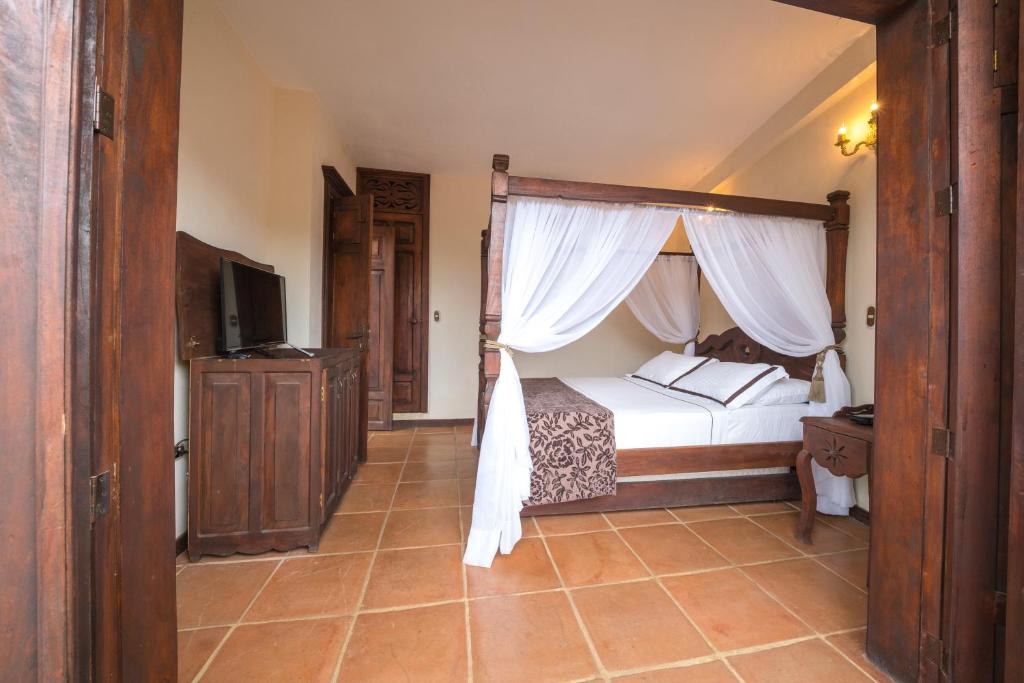 Postel nebo postele na pokoji v ubytování Nueva Granada Hotel Colonial -Centro Histórico-