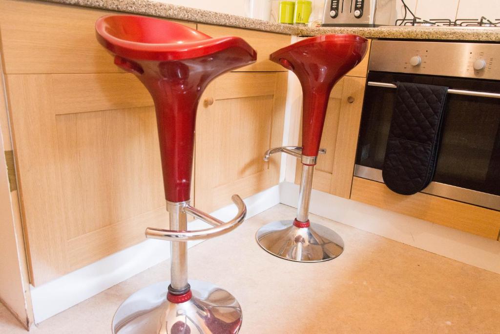 two red stools sitting on the floor in a kitchen at QUEEN GUEST HOUSE in Gillingham