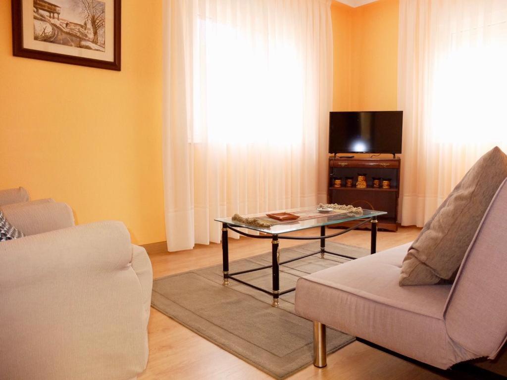 sala de estar con mesa, sofá y TV en BARRIO DE ABAJO 50 2º, en Felechosa