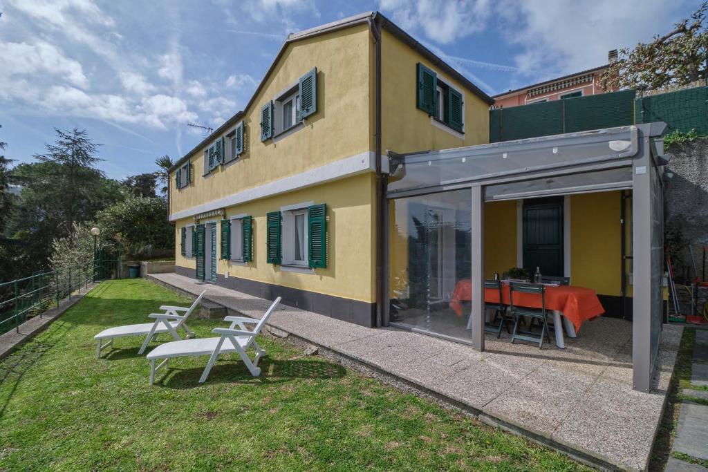 una casa amarilla con una mesa y sillas en el patio en Villino Adelaide, en Rapallo