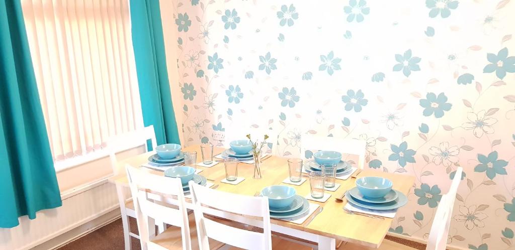 a dining room with a table with blue dishes on it at Fearnhead House in Warrington