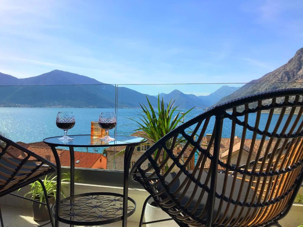 a balcony with a table and two glasses of wine at Vacanza, Sea view in Kotor
