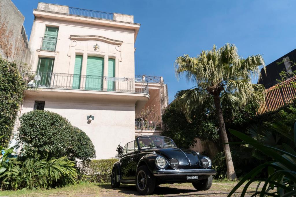 ein schwarzes Auto, das vor einem Haus parkt in der Unterkunft Inn Liberty in Giarre