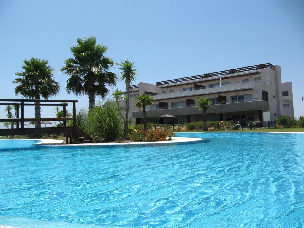 a large swimming pool in front of a building at Life Apartments El Rompido in El Rompido
