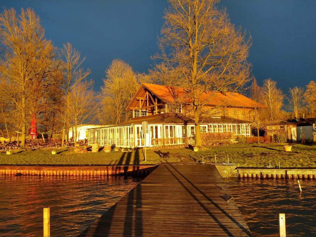 a house on the shore of a lake with a dock at Seewirt Ecking in Riedering