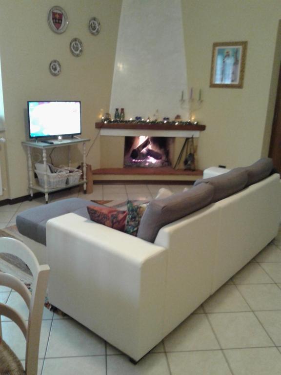 uma sala de estar com um sofá branco e uma lareira em Via del Fusato 13 Casa Carla em Chiusi della Verna