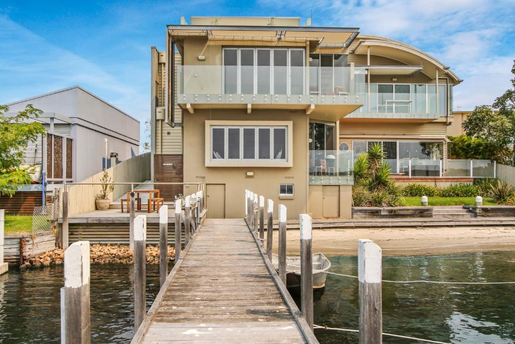 a house on the water with a dock at A Window on the Bay in Metung