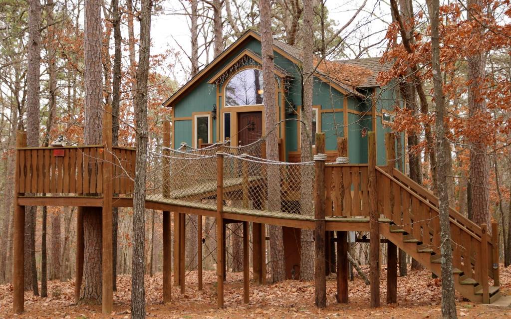 una casa en el árbol en medio del bosque en The Grand Treehouse Resort en Eureka Springs