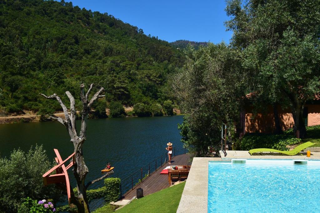a swimming pool with a view of a lake at Casas de Pousadouro in Baião