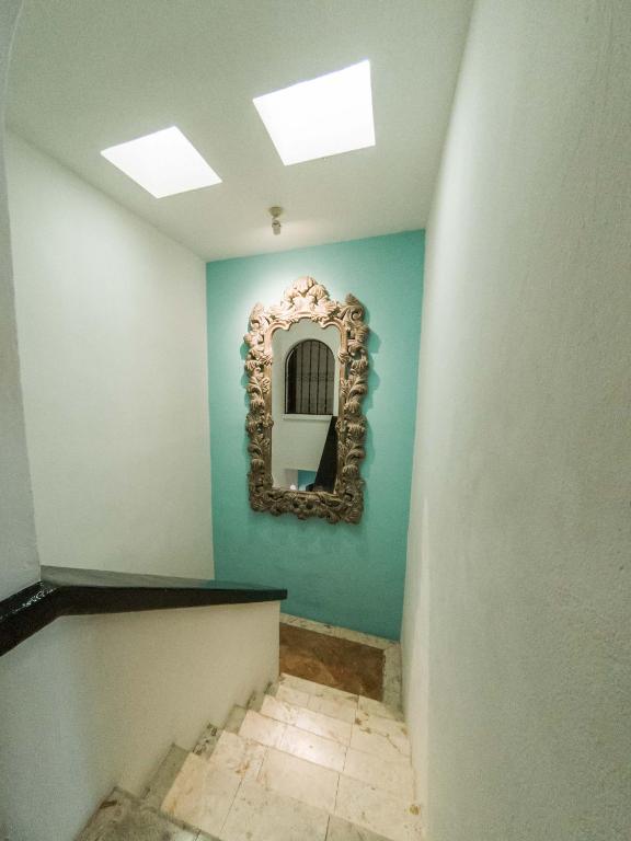 a hallway with a mirror on a blue wall at La Villa du Golf à Cancun Hotel Boutique in Cancún
