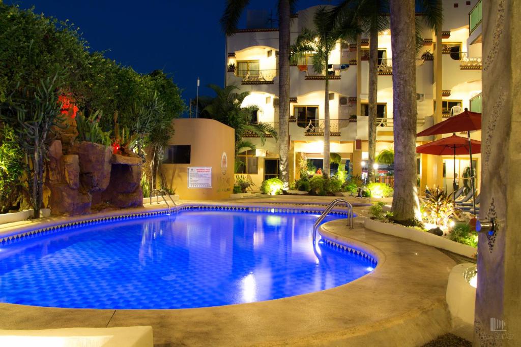a swimming pool in front of a hotel at night at MarySol Las Palmas in Rincon de Guayabitos