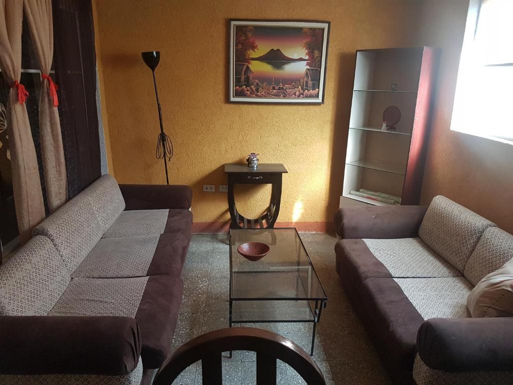 Sala de estar con 2 sofás y mesa en Río rooms in City Center en Quetzaltenango