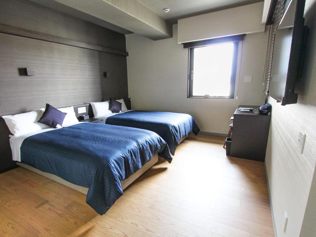 Postel nebo postele na pokoji v ubytování HOTEL LiVEMAX PREMIUM Himejieki-Minami