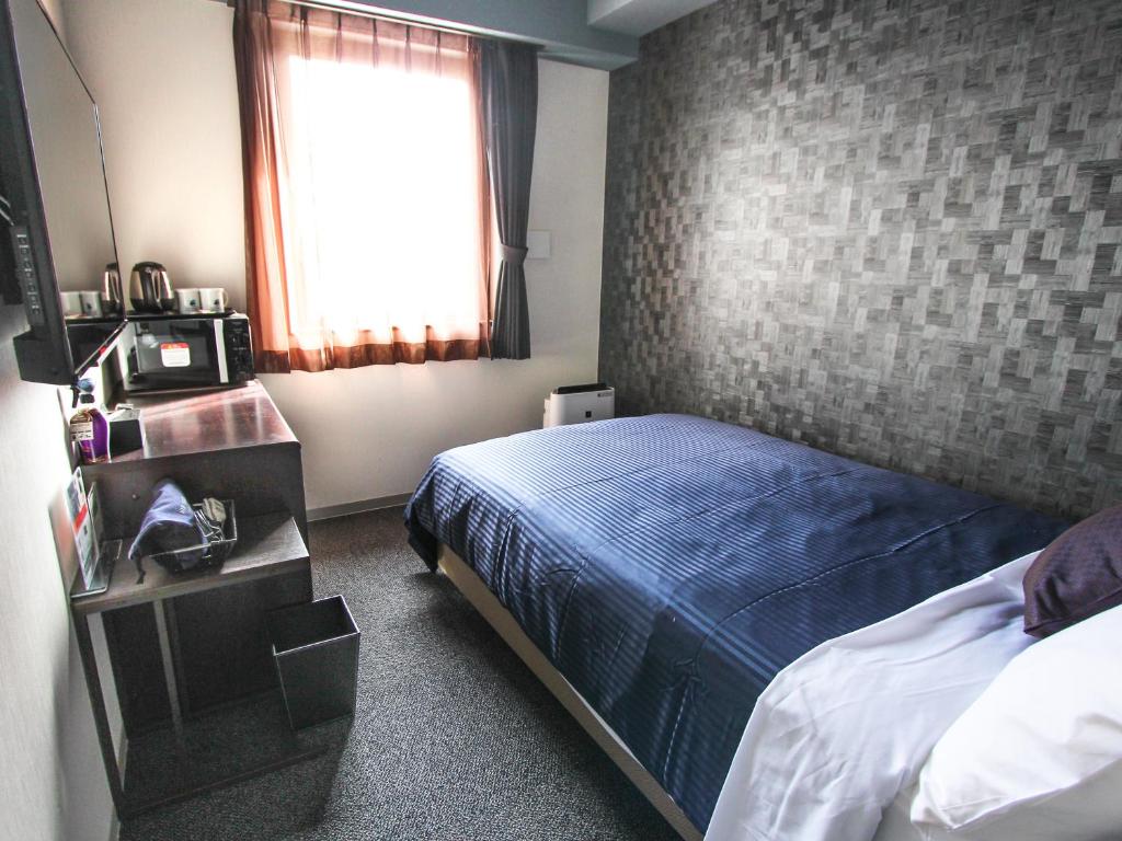 Postel nebo postele na pokoji v ubytování HOTEL LiVEMAX PREMIUM Himejieki-Minami