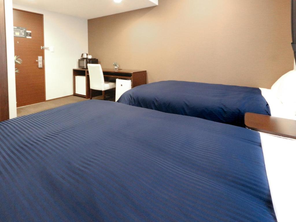 Postel nebo postele na pokoji v ubytování HOTEL LiVEMAX Kayabacho