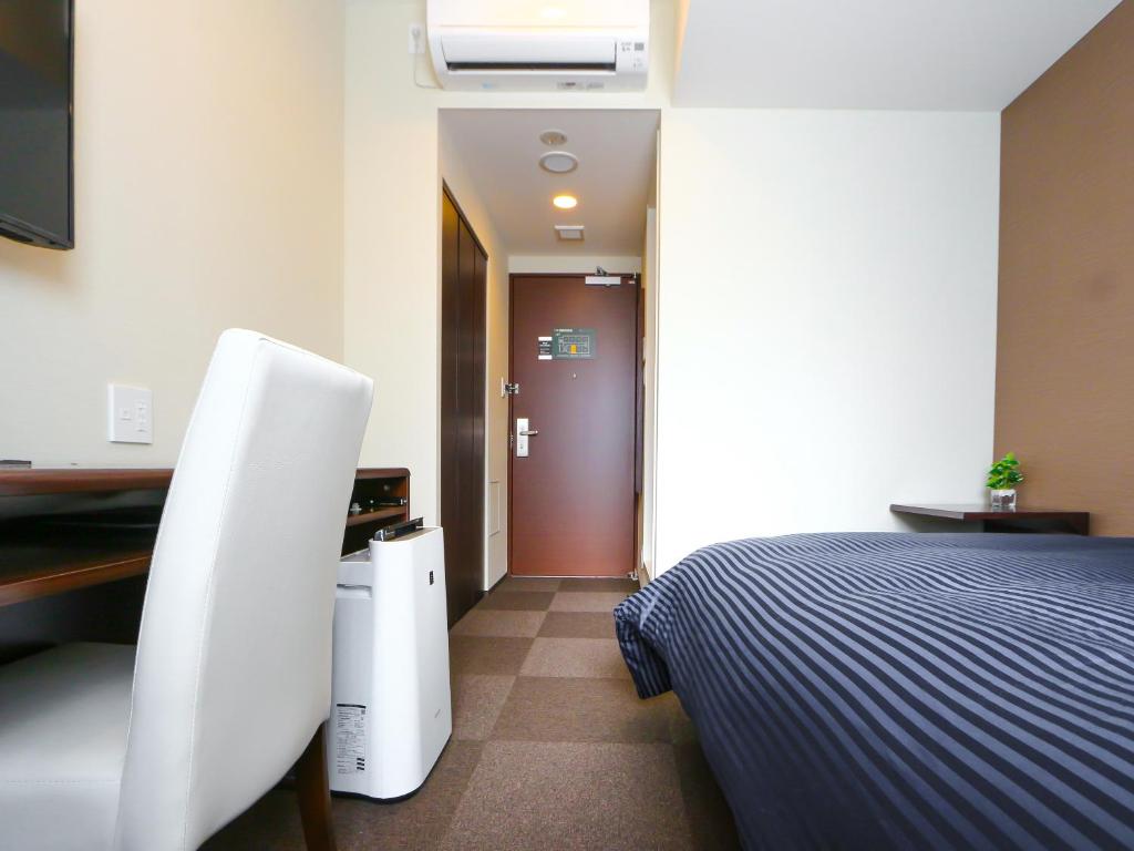 Postel nebo postele na pokoji v ubytování HOTEL LiVEMAX Kayabacho