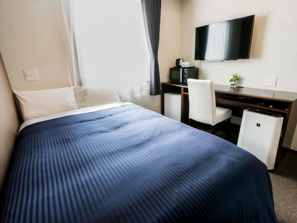 Postel nebo postele na pokoji v ubytování HOTEL LiVEMAX Kayabacho