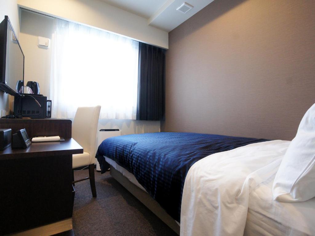 Postel nebo postele na pokoji v ubytování HOTEL LiVEMAX Osaka Umeda Nakatsu