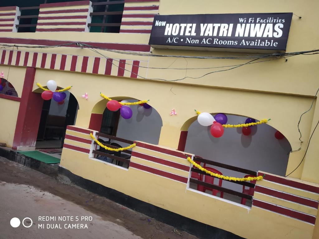 un bâtiment avec deux fenêtres et un panneau sur celui-ci dans l'établissement New Hotel Yatri Niwas, à Varanasi