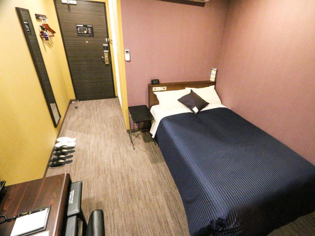 Postel nebo postele na pokoji v ubytování HOTEL LiVEMAX Mikawaanjo Ekimae