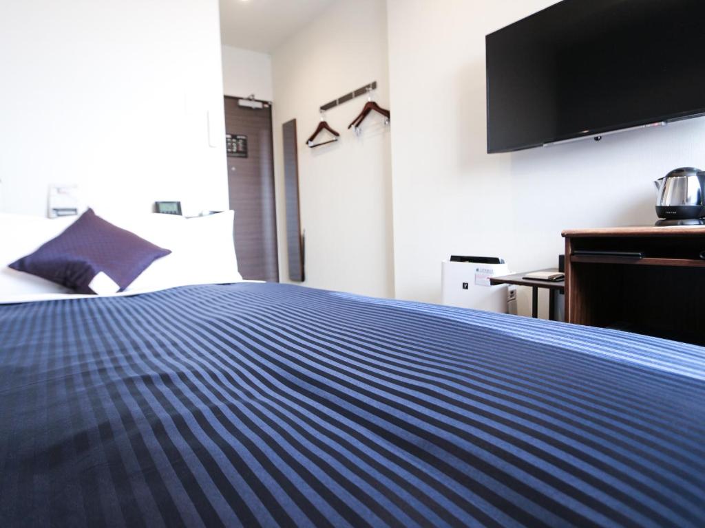 Postel nebo postele na pokoji v ubytování HOTEL LiVEMAX Tokyo Ayase-Ekimae