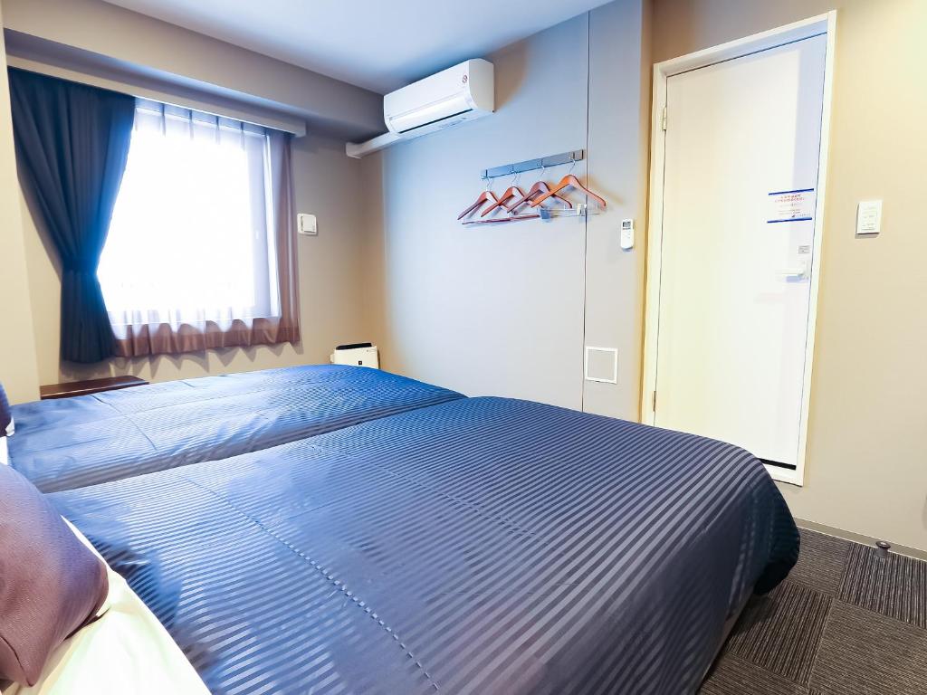 Postel nebo postele na pokoji v ubytování HOTEL LiVEMAX Yokohama-Eki Nishiguchi