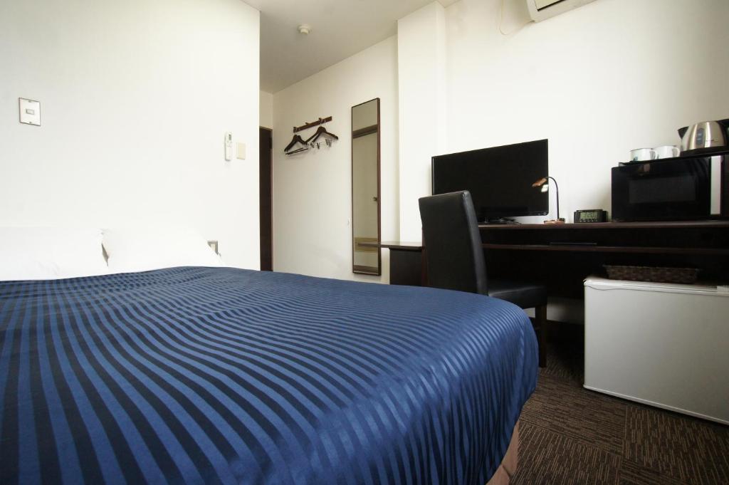 Postel nebo postele na pokoji v ubytování HOTEL LiVEMAX BUDGET Gunma Numata