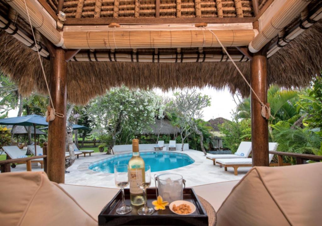 a table with a bottle of wine next to a swimming pool at Aashaya Jasri Resort in Jasri